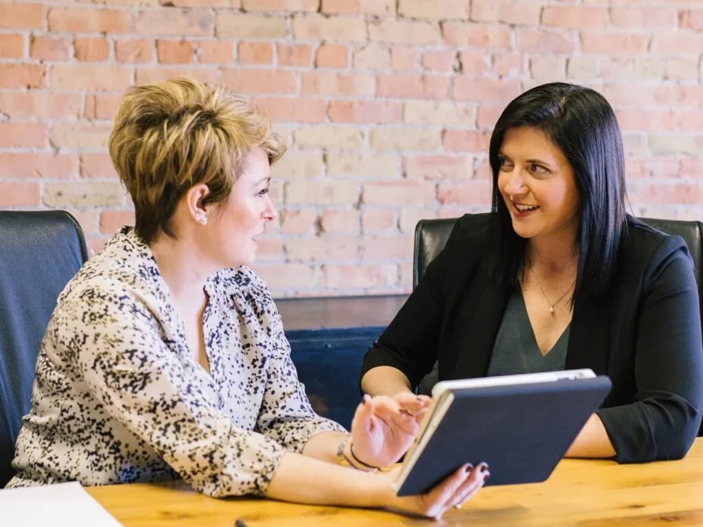 Two professionals reviewing case management records on a tablet